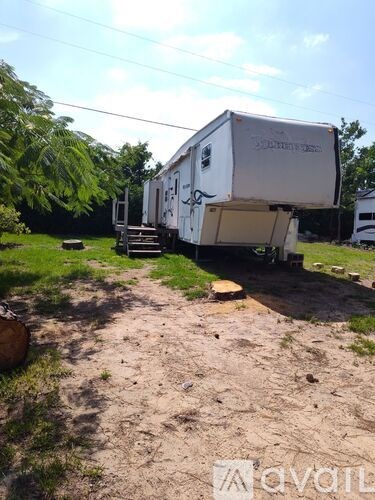 A white RV is parked in a grassy area.