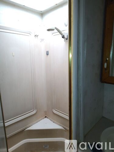A bathroom with a toilet, sink and shower.
