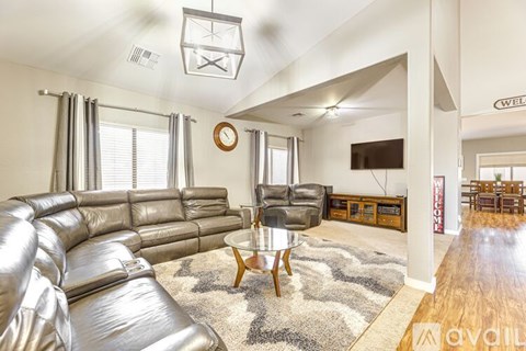 A living room with a silver couch and a wooden coffee table.