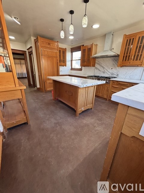 A kitchen with wooden cabinets and a marble countertop.