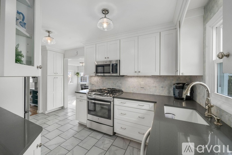 A kitchen with white cabinets and a black countertop.
