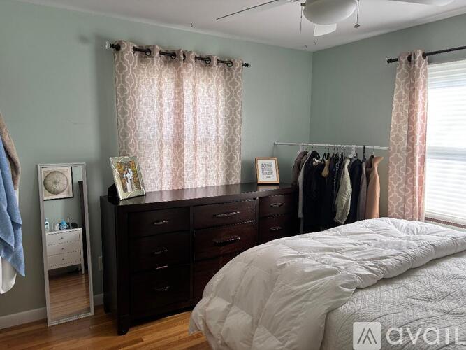 A bedroom with a bed, dresser, and mirror.