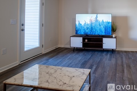 A living room with a television and a marble coffee table.