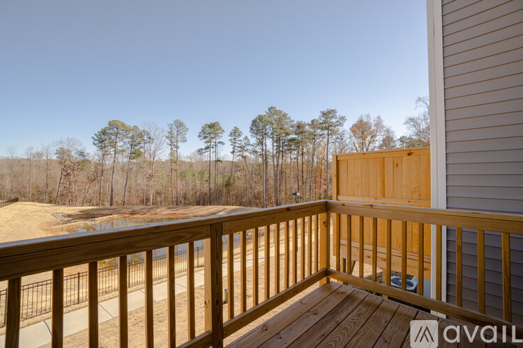 A wooden deck with a railing and a view of a wooded area.