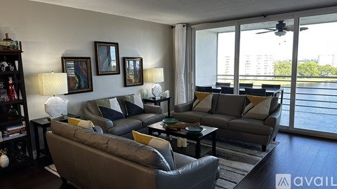 A living room with a grey couch and a black bookshelf.
