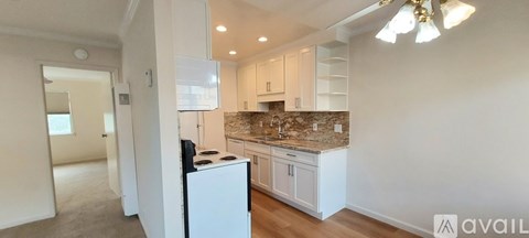 A kitchen with a granite countertop and white appliances.