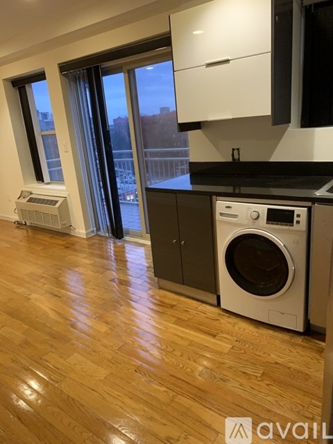 A kitchen with a washing machine and a window.