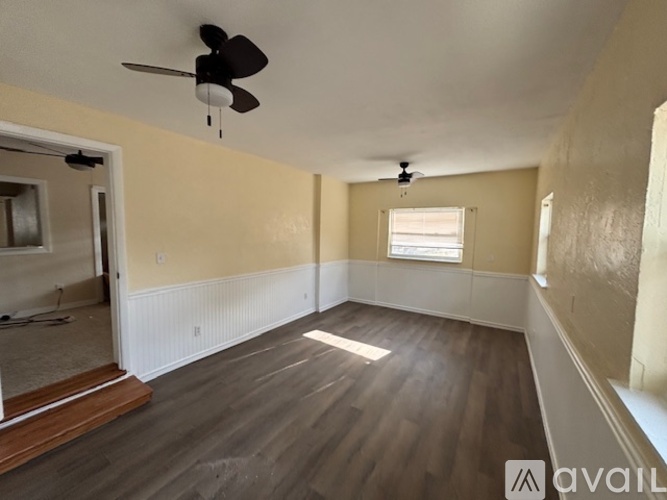A room with a ceiling fan and a window.