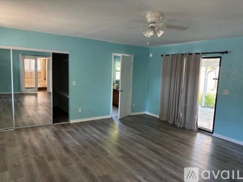 A spacious room with a ceiling fan and sliding glass doors.