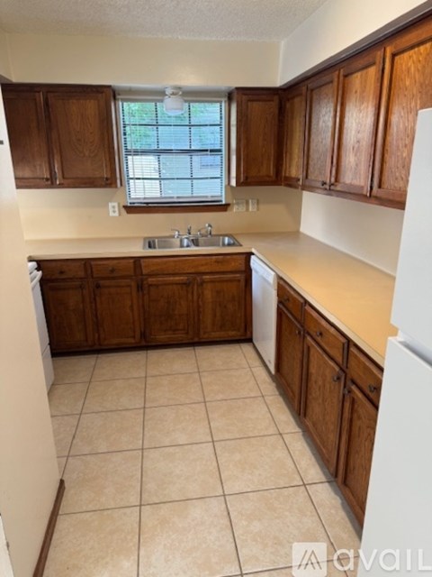 A kitchen with wooden cabinets and a white fridge.