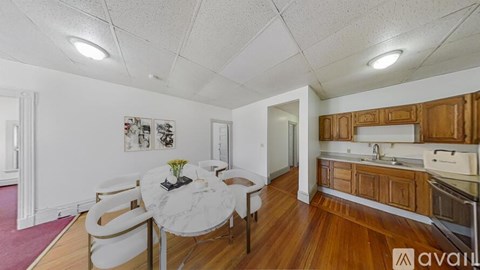 A kitchen with wooden cabinets and a white table with chairs.