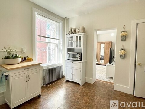A kitchen with white cabinets and a wooden countertop.