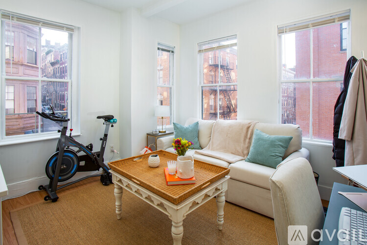 A living room with a couch, a coffee table, and a vacuum cleaner.