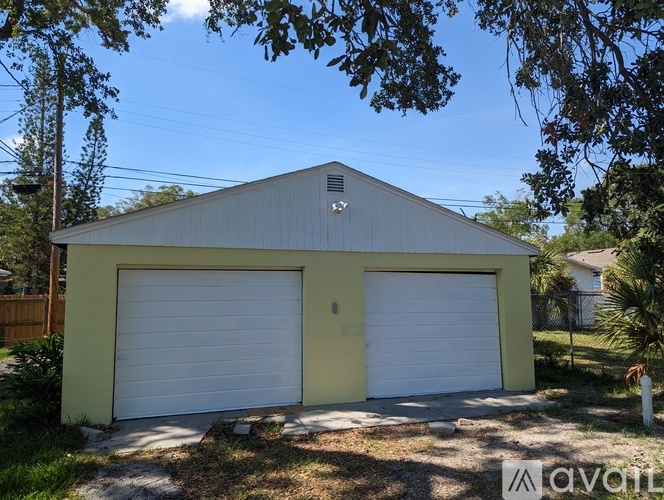 A two-car garage with a yellow exterior and white doors.