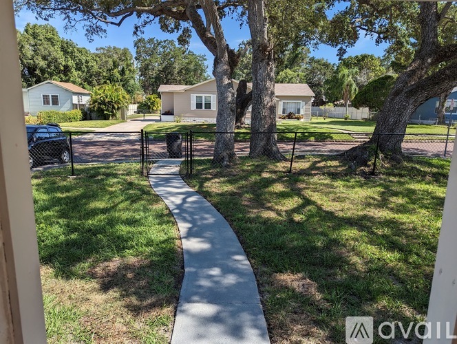 A residential area with houses and a tree-lined sidewalk.