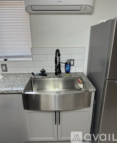 A kitchen with a sink and a refrigerator.