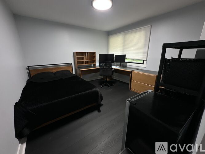 A bedroom with a bed, desk, and chair.