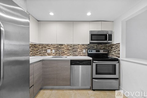 A kitchen with a stainless steel refrigerator, microwave, oven, and dishwasher.