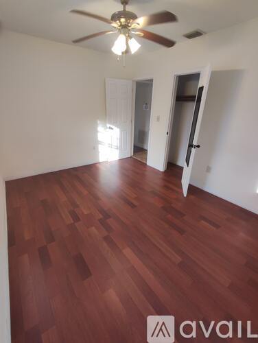 A room with a wooden floor and a ceiling fan.