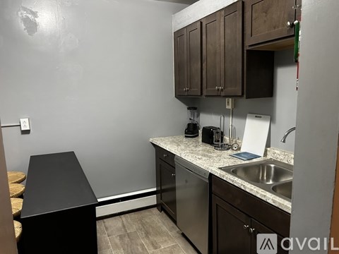 A kitchen with a black counter and stainless steel appliances.