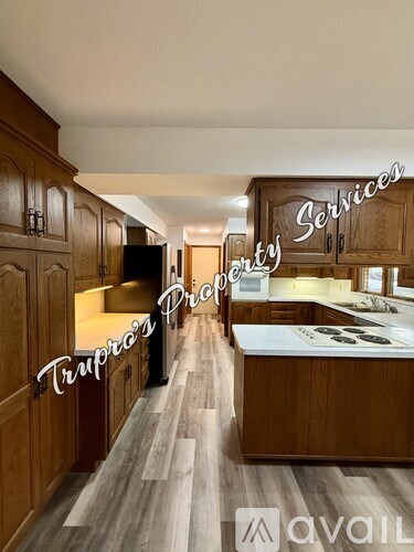 A kitchen with wooden cabinets and a sign that says "Trupro's Property Services".