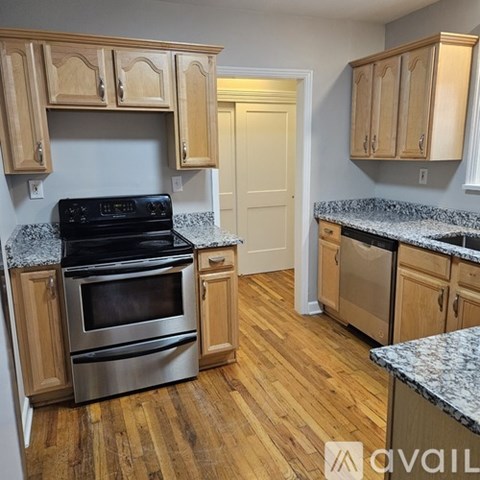 A kitchen with wooden cabinets and a black stove top oven.
