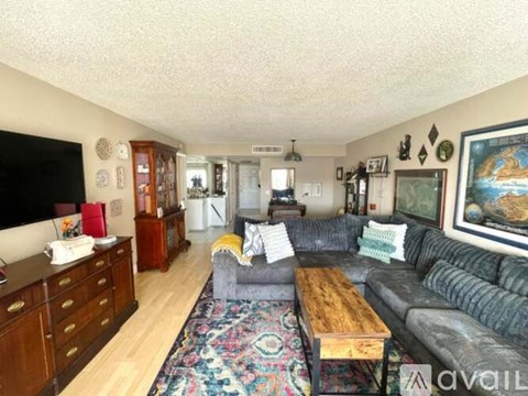 A living room with a grey couch and a wooden coffee table.