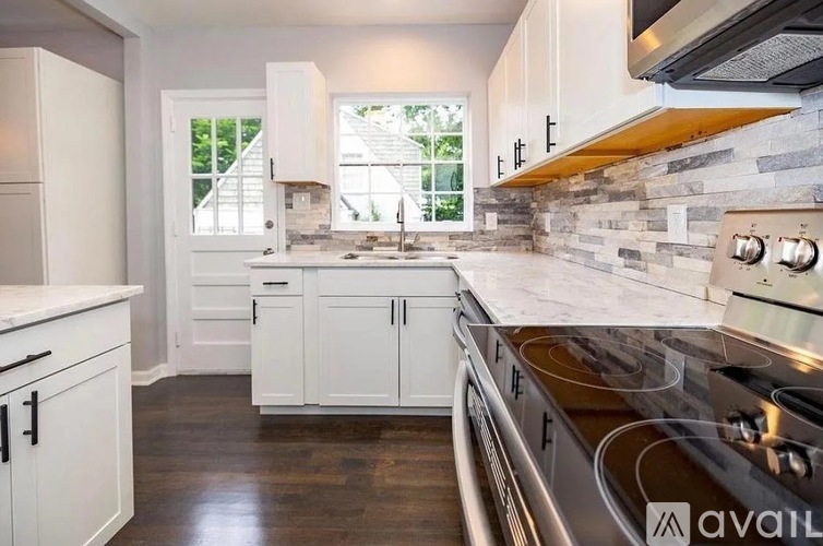 A kitchen with white cabinets and a stainless steel oven.