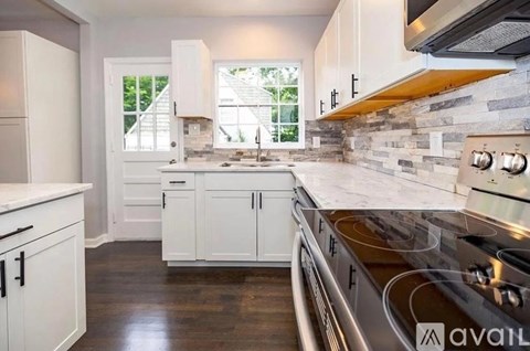 A kitchen with white cabinets and a stainless steel oven.