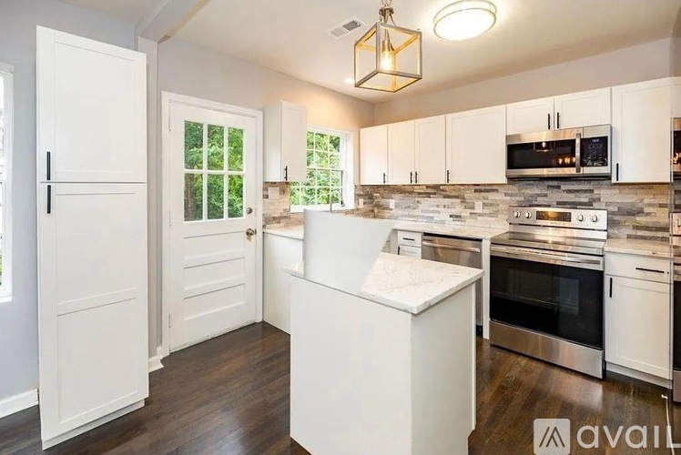 A kitchen with white cabinets and a white island.