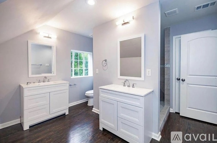 A bathroom with two sinks and a large mirror.