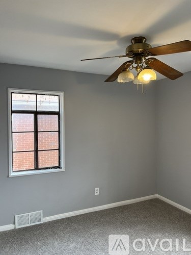 A room with a ceiling fan and a window.