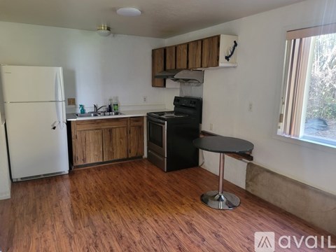 A kitchen with a black stove top oven and a white refrigerator.