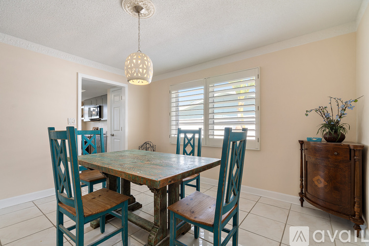 A dining room with a table and chairs.