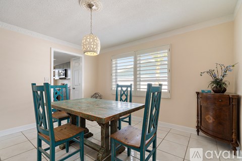 A dining room with a table and chairs.
