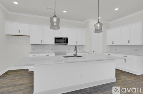 A modern kitchen with white cabinets and a central island.