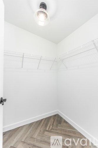 A white room with a wooden floor and a door.