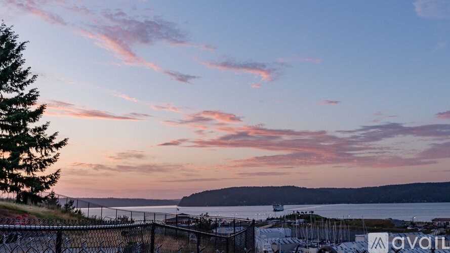 A beautiful sunset view with a fence and a tree on the left side.