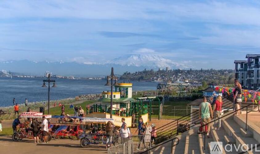 A group of people are walking on a boardwalk near the water.