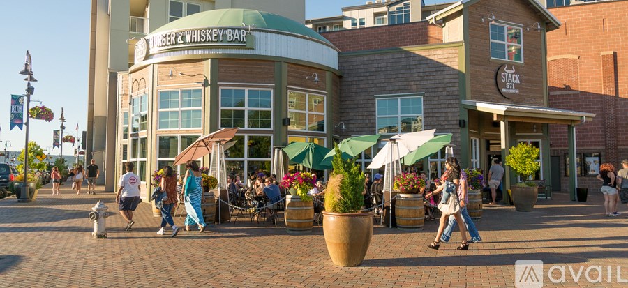 A group of people are walking in front of a building with a green awning.
