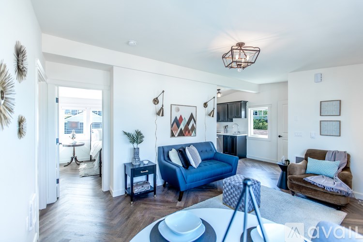A living room with a blue couch and a brown armchair.
