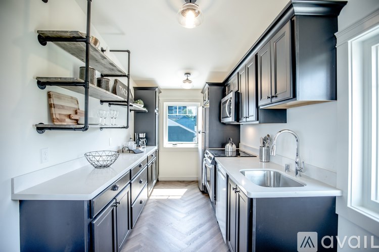 A kitchen with black cabinets and a white countertop.