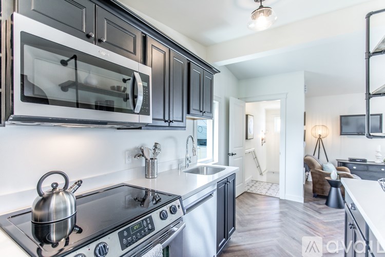 A modern kitchen with a black stove top oven and a black microwave above it.