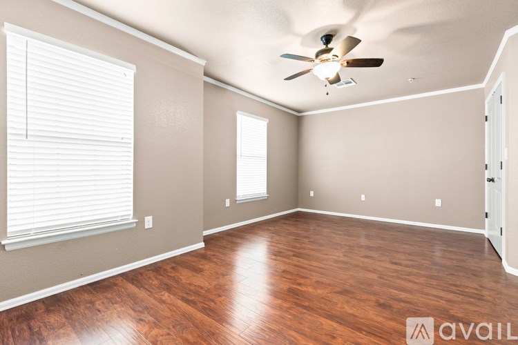 A room with wooden flooring and a ceiling fan.