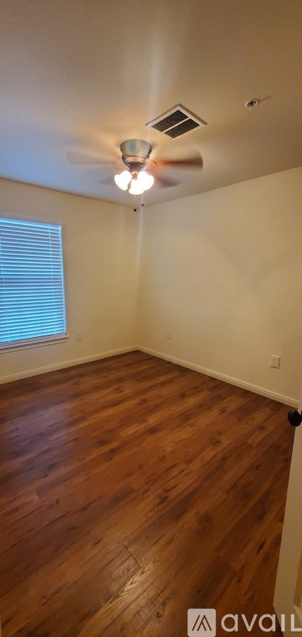 A room with wooden flooring and a ceiling fan.
