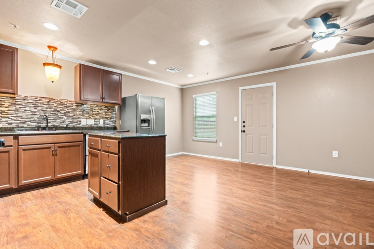 A kitchen with wooden cabinets and a stone backsplash is available.