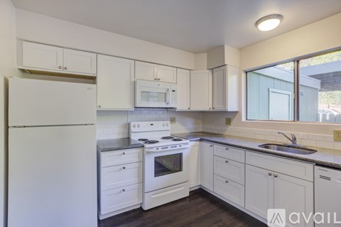 A kitchen with white appliances and cabinets.