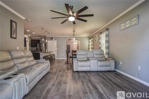 A living room with a white sofa and a ceiling fan.