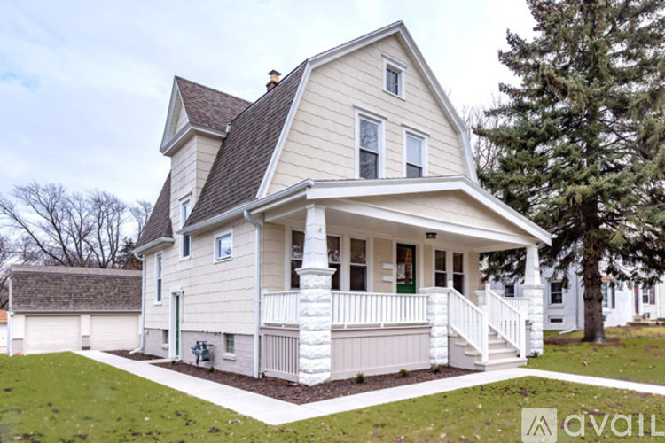A two-story house with a front porch and a green door.