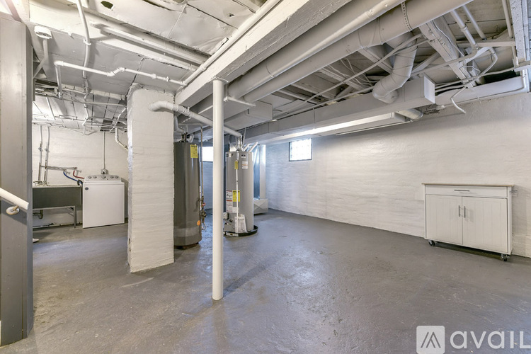 A spacious industrial-style room with white walls and a concrete floor.